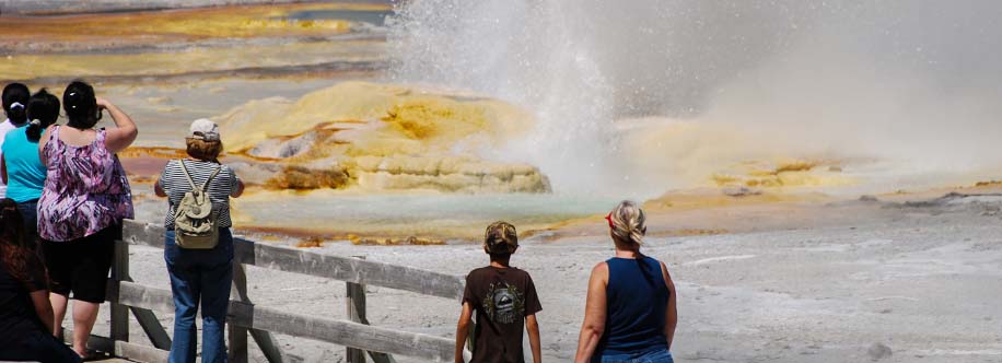 people watching small geyser in yellowstone national park